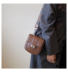 Détail du petit sac rétro marron avec bandoulière large à imprimé ethnique chic