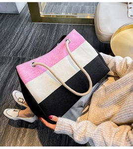 Detail der dreifarbigen Canvas-Tasche mit rosa beige schwarzen Streifen und Seilgriff