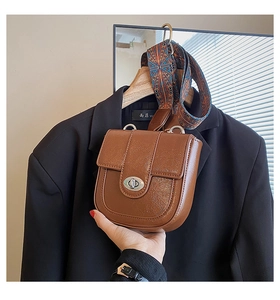 Détail d'un sac bandoulière marron rétro avec large sangle géométrique et fermoir métal