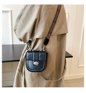 Détail d'un sac bandoulière noir vintage avec large sangle bohème et fermoir argenté