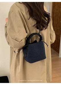 Detail of dark blue felt bucket bag featuring a thick spiral woven handle and drawstrings