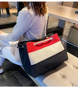 Details der dreifarbigen Canvas-Tasche mit Seilgriffen und verstärkten Metallösen