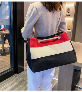 Modische Canvas-Tasche mit Color-Blocking-Design und Seilgriffen getragen von einem Model