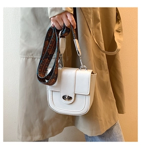 Détail du sac blanc avec bandoulière imprimée rétro et verrou en métal argenté