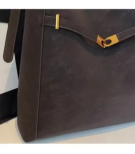 Close-up of deep brown frosted leather texture and premium gold metal buckle detail