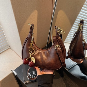 Retro brown leather crescent hobo bag with a stylish cherry charm and golden hardware