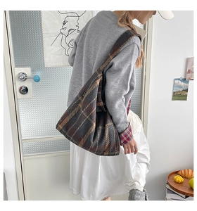 Detail der Vintage-Tweed-Tasche mit Karomuster und strukturiertem Schultergurt