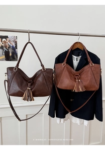 Detailed shot of large retro tote bags with leather tassels and woven texture details