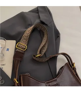 Detail of wide woven herringbone strap and vintage brown leather shoulder bag texture