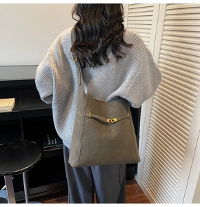 Detail view of large olive green faux suede hobo bag with a gold metal buckle strap