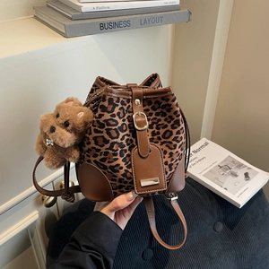 Leopard print suede bucket bag with leather trim and plush dog charm accessory