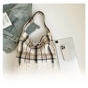 Flachbild der Vintage Tweed-Einkaufstasche mit Tablet und Zeitschriften auf Jeansjacke
