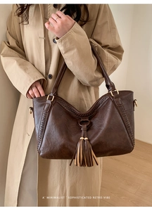 Detail of dark brown retro tote bag featuring stylish fringe and woven side stitching