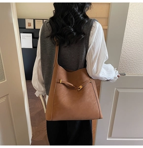 Caramel brown matte faux suede shoulder bag with gold buckle and wide strap detail
