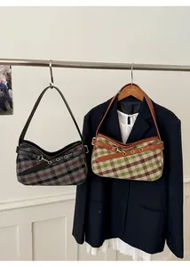 Detail of French vintage plaid shoulder bags in grey and green tweed with metal accents