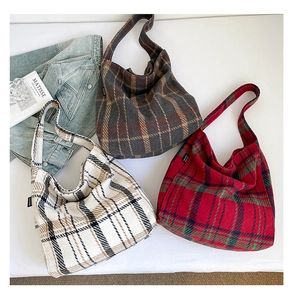 Nahaufnahme von Vintage-Stofftaschen mit Karomuster in Grau, Beige und Rot für Damen