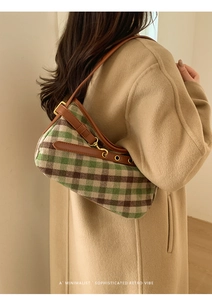 Model wearing retro plaid baguette bag with brown leather trim and gold hardware details