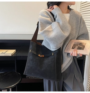 Detail of vintage matte black faux suede tote with brown strap and gold buckle