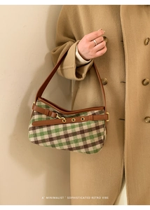 Close-up of retro plaid underarm bag with leather belt buckle and gold metal hardware
