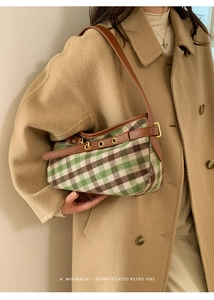 Detail of vintage plaid underarm bag featuring premium leather trim and golden buckles