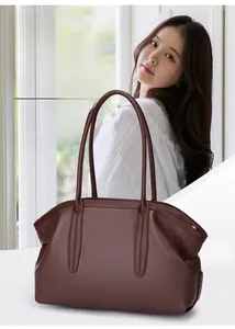 Detail of a brown lychee pattern leather tote bag showing a sleek vintage shoulder strap