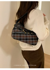 Retro plaid shoulder bag with black leather strap and gold buckle on a model