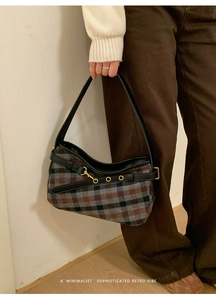 Detail of retro plaid shoulder bag featuring tweed fabric and leather strap with gold buckle