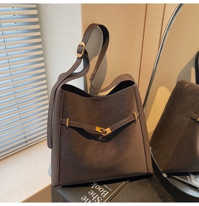 Detailed view of the dark brown matte leather tote bag with gold buckle and adjustable strap