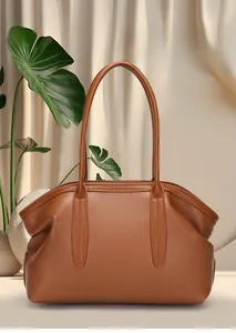 Detail of a brown cowhide tote bag with litchi grain texture and spacious design