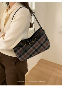 Close-up of retro plaid fabric and golden metal buckle on the minimalist baguette bag