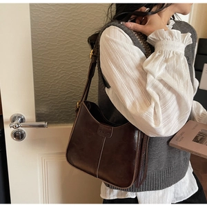 Detail of vintage chocolate brown bucket bag with decorative stitching and brand logo