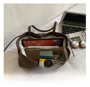 Interior view of brown tote bag showing large capacity with laptop and makeup