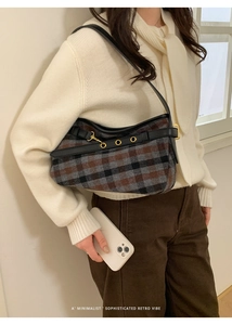 Close-up of retro plaid fabric shoulder bag with leather trim and gold metal rings