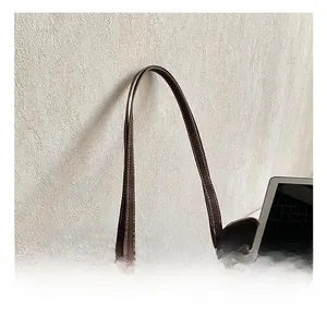 Detail view of dark brown suede tote bag with contrast stitching and metal ring attachment
