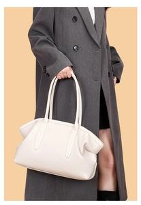Detail of white lychee grain leather tote bag with soft pleated texture and dual handles