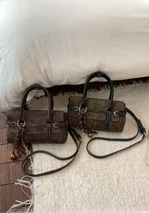 Détail de sacs à bandoulière rétro en daim avec poignées rondes et charms sur tapis doux