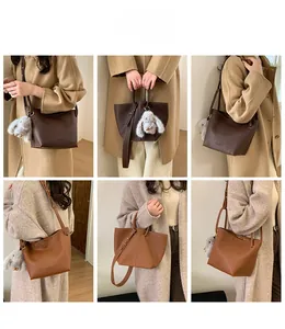 Brown leather bucket bag styled as handbag and crossbody with a cute plush bunny charm