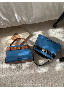 Détail du sac Kelly en denim bleu avec fermoir rotatif doré et lanières en cuir