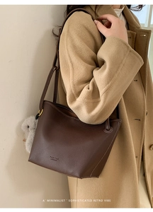 Retro dark brown pebbled leather bucket bag with plush rabbit charm and logo detail