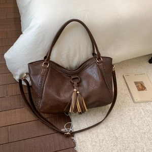 Vintage brown leather tote bag with stylish fringe tassel and woven texture detailing