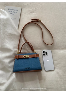Vue de dessus d'un sac rétro en jean et cuir avec fermoir doré et smartphone