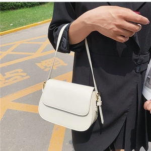 Minimalist white leather shoulder bag with gold hardware and flap closure for women