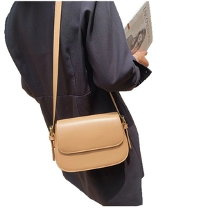 Minimalist vintage flap crossbody bag in khaki leather worn by a model on a white background