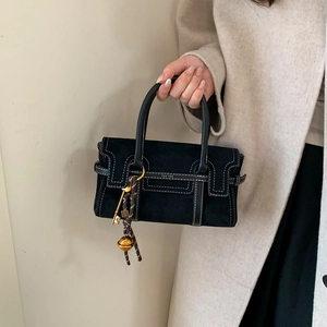 Sac à main minimaliste en daim noir avec surpiqûres blanches et détails de breloque dorée