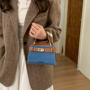 Mini sac à main en denim et cuir marron avec fermoir tournant doré porté par un mannequin