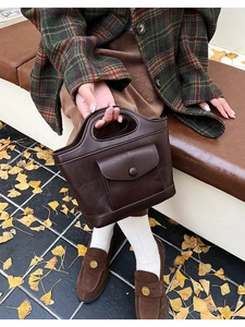 Outdoor shot of dark brown PU leather tote bag with hollow round handle and front flap pocket