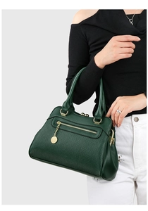 Detail der dunkelgrünen Handtasche mit Litschi-Textur und goldenen Metallakzenten