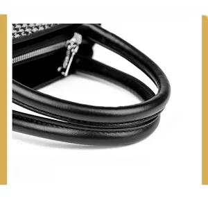 Close-up of houndstooth fabric texture and black leather handle with silver zipper detail