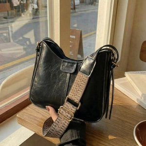 Classic black leather hobo bag with a wide adjustable strap and golden metal hardware