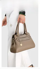 Nahaufnahme braune Handtasche aus Leder mit Litschimaserung und goldenem Anhänger